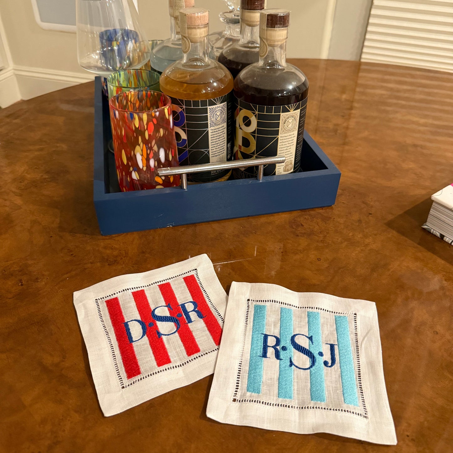 Decorative items including a small shrine and two embroidered towels on a wooden surface.