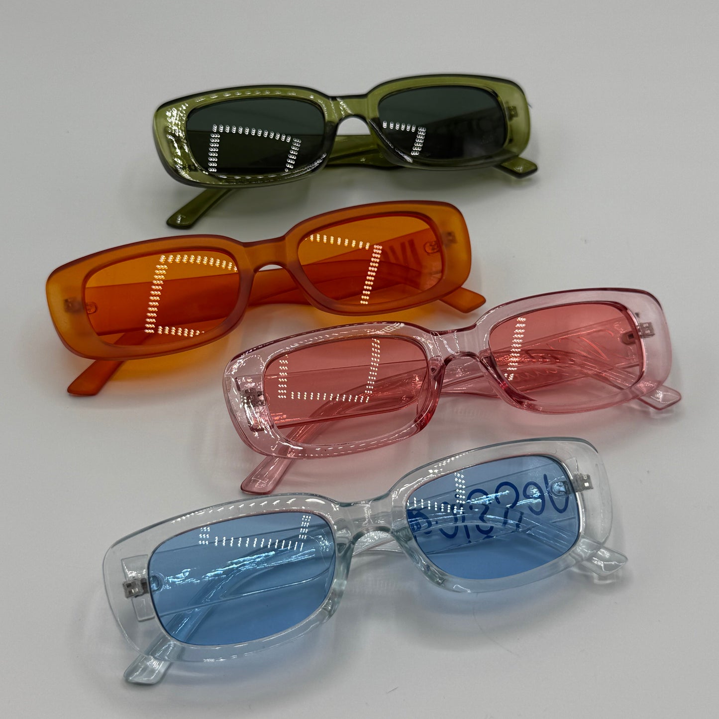 Four pairs of colorful sunglasses on a white background