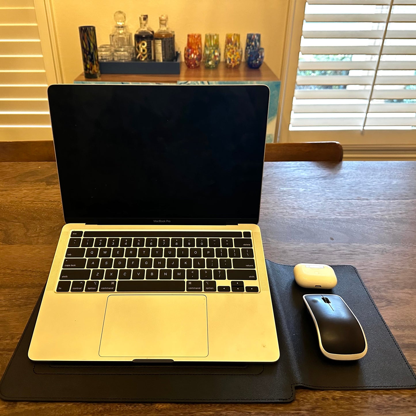 Laptop on a desk with a mouse and mouse pad in a home office setting