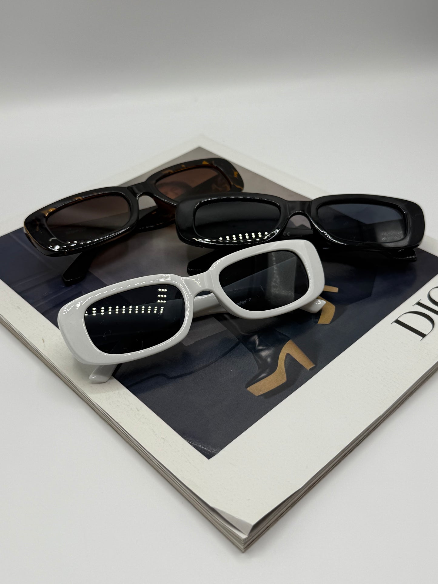 Collection of sunglasses on a branded box with 'Dior' logo.