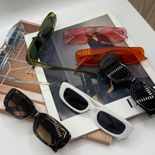 Collection of sunglasses on a white surface with a blurred background