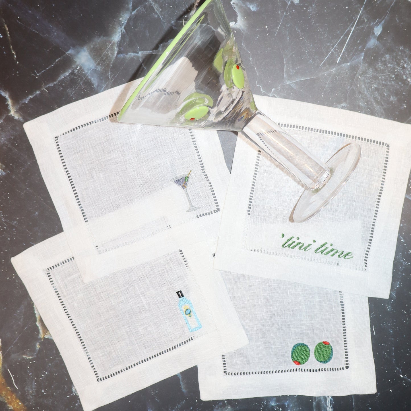 Set of cocktail napkins with illustrations on a dark marble surface