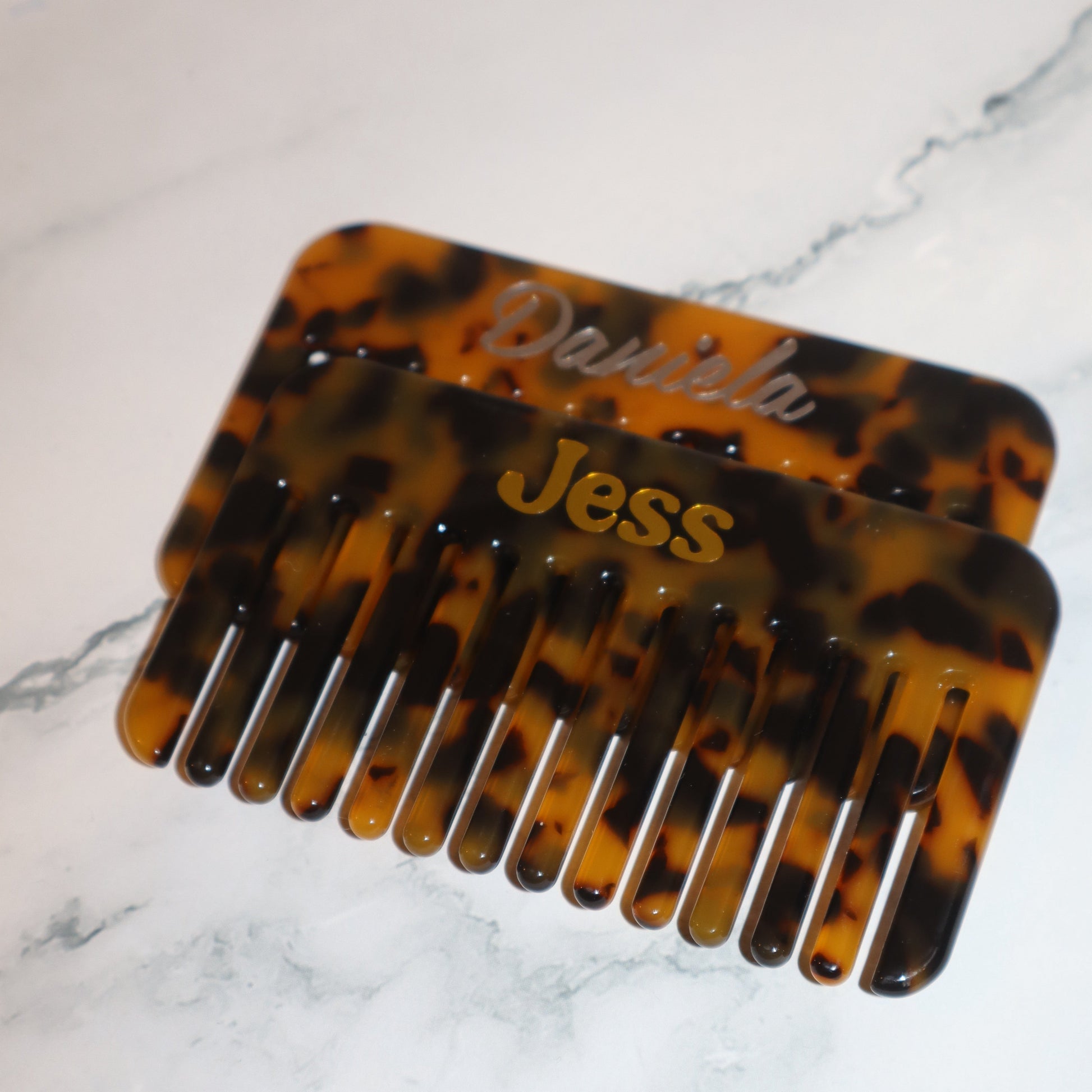 Tortoiseshell comb with 'Jess' engraved on a marble background