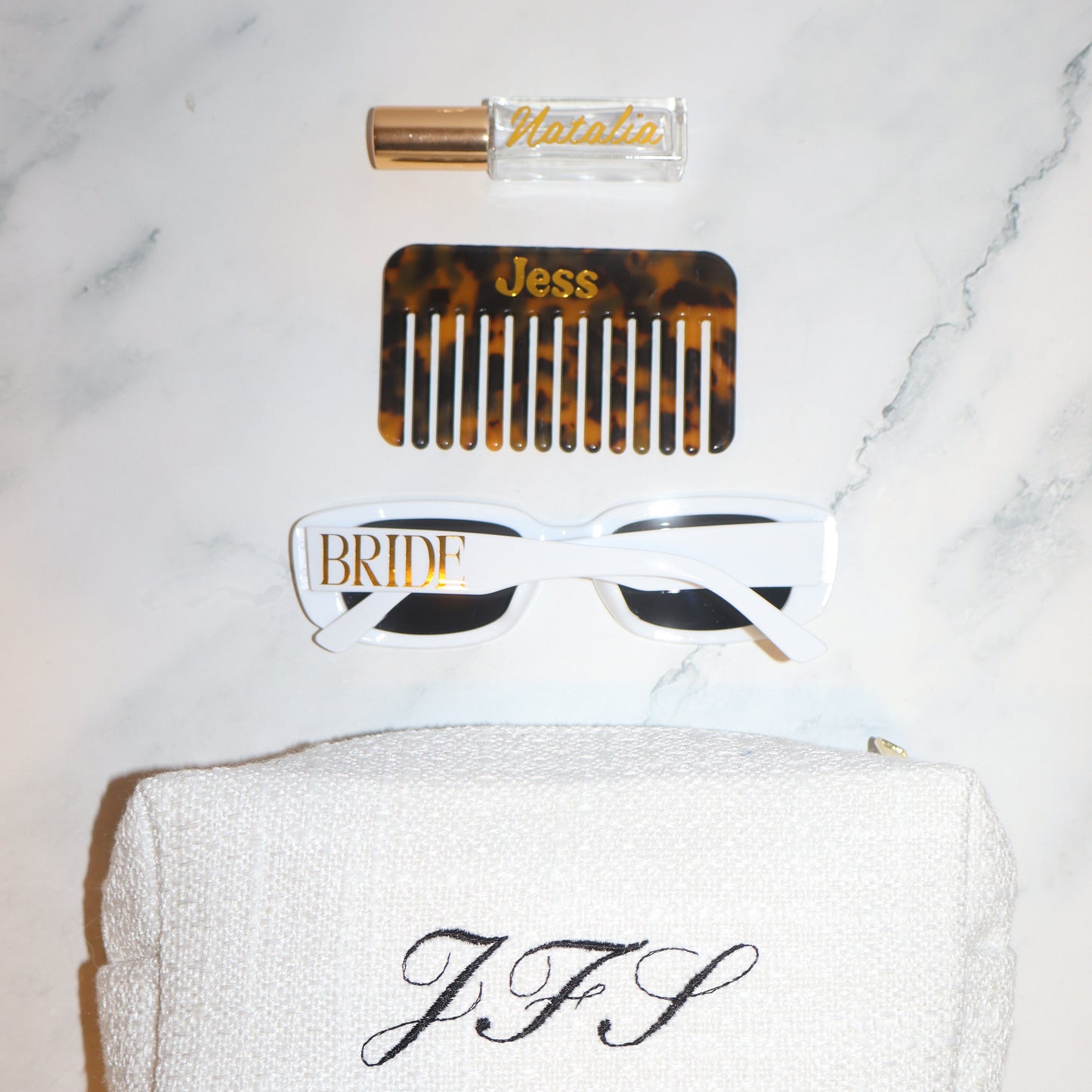 Set of hair care products including a comb, bottle, and towel on a marble surface