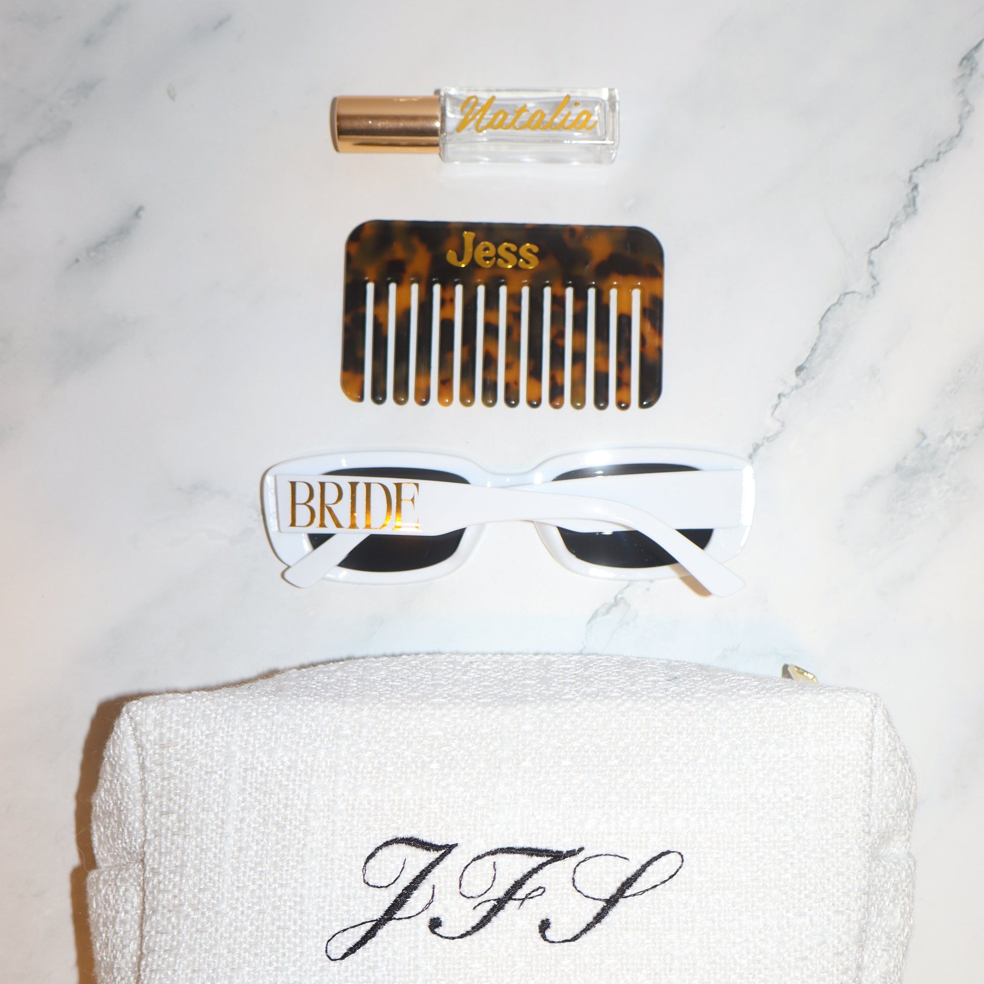 Set of hair care products including a comb, bottle, and towel on a marble surface
